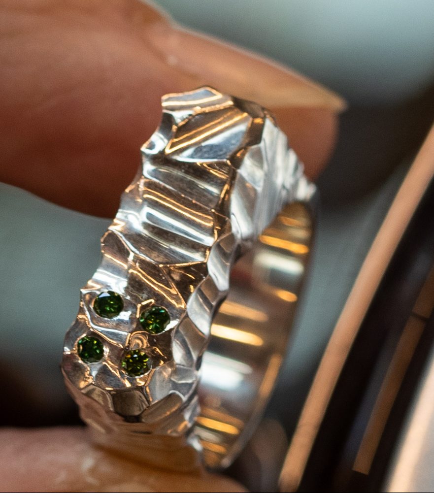Zilveren herenring met groene diamanten.