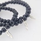 Exclusieve armband van zwarte tourmalijn kralen met olijftak hanger